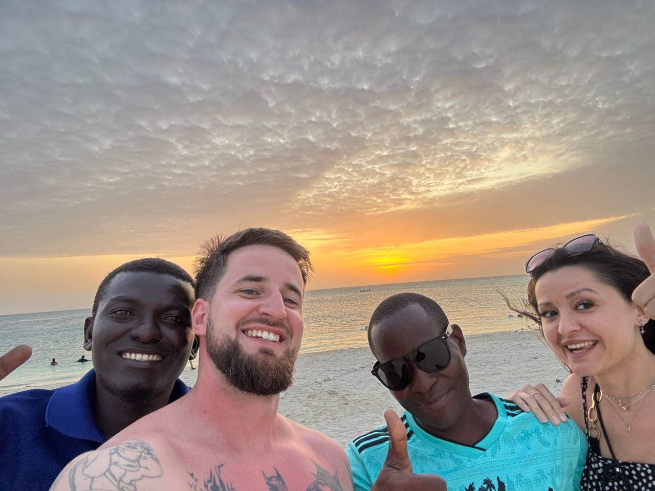 Goldener Sonnenuntergang über dem Meer vor Sansibar mit einem Dhow am Horizont